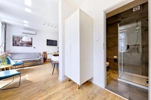 a white apartment with a glass door and a living room at Apartamenty Cinema in Poznań