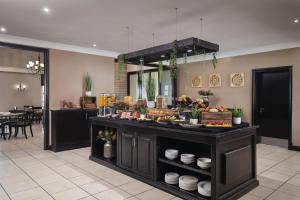 a buffet in a room with food on display at Protea Hotel by Marriott Bloemfontein in Bloemfontein