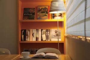 a table with a lamp and a book on it at Horizon Inn in Taipei