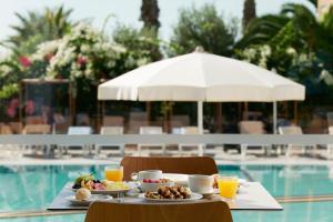 a table with food and drinks on it next to a pool at Atlantica Sungarden Park in Ayia Napa