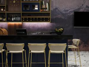 a bar with white chairs and a black counter at Atlantica Sungarden Park in Ayia Napa