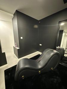 a black chair in a room with a mirror at # Le 7 # Nuitée torride, balnéo, tantra Mulhouse centre in Mulhouse