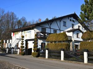 a white building with a fence in front of it at Hotel Sjesta in Mikołów