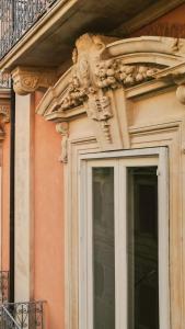 a building with a carving on the side of a window at Iconic Ortigia Residence - CarAccess PrimeLocation DiningGuide in Siracusa