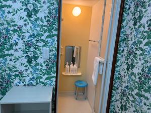 a bathroom with a shower with blue and white flowers at Guest House新今宫 in Osaka
