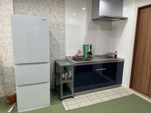a small kitchen with a sink and a refrigerator at Guest House新今宫 in Osaka