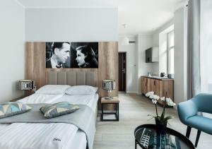 a bedroom with two beds and a living room at Apartamenty Cinema in Poznań