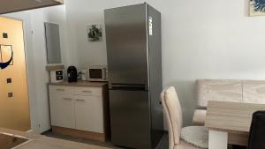 a kitchen with a stainless steel refrigerator and a table at Ferienwohnung Casa Amedea in Aigen im Ennstal