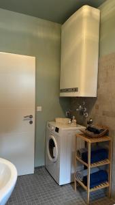 a washing machine in a bathroom with a sink at Ferienwohnung Casa Amedea in Aigen im Ennstal +17 photos