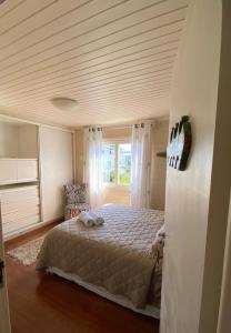 a bedroom with a bed and a large window at Pousada Casa Campeche - Floripa in Florianópolis