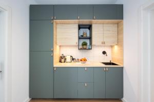 eine Küche mit blauen Schränken und einer Spüle in der Unterkunft Luxury Apart-Hotel in Bukarest