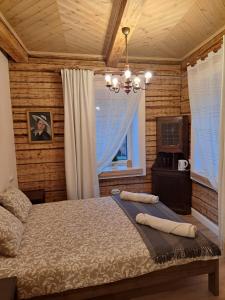 una camera da letto con un letto e un lampadario di Stebuklėlis a Pakruojis