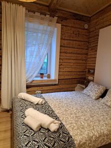 una camera da letto con un letto con asciugamani sopra di Stebuklėlis a Pakruojis