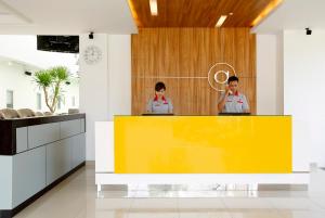 dos personas de pie detrás de un mostrador amarillo en una cocina en Amaris Hotel Sunset Road - Bali, en Kuta