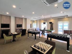 a living room with chess tables and a room with a pool table at Experience Elegance at Chambre Honore in Iloilo City