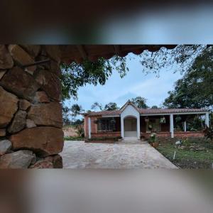 a house with a stone wall and a driveway at Casa Campestre la Martina in La Honda