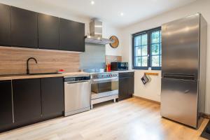 cocina con electrodomésticos de acero inoxidable y suelo de madera en Le Perchoir du Grand Valtin - Gîte 9 personnes - Altitude 830, en Ban-sur-Meurthe-Clefcy