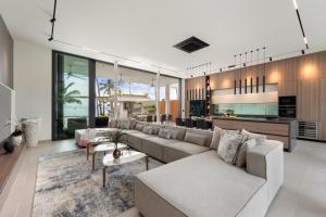 ein Wohnzimmer mit Sofas und eine Küche in der Unterkunft Emotion Beachfront Villas in Koh Samui