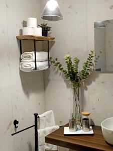 ein Bad mit einem Tisch, Handtüchern und einem Waschbecken in der Unterkunft Dimora al Capo in Palermo