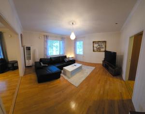 un soggiorno con un divano nero e una TV di Rauma Room's House 11 a Rauma