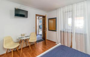 ヤドラノボにあるApartments Mare Jadranovoのベッドとテーブルと椅子のある寝室