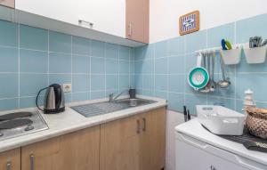 ヤドラノボにあるApartments Mare Jadranovoの青いタイルの壁のキッチン、シンクが備わります。 +37枚の写真