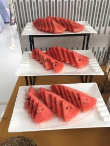 zwei weiße Platten mit Scheiben Wassermelone drauf in der Unterkunft Central Resident in Chiang Mai