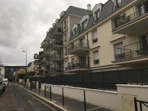 an apartment building with balconies on a city street at Charmant studio in La Garenne-Colombes