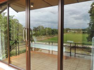a view from a glass door of a balcony with a view at บ้านกลางเกาะ รีสอร์ท in Uthai Thani