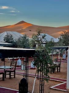 a group of tables and chairs in the desert at Desert Camp Merzouga Nights in Merzouga