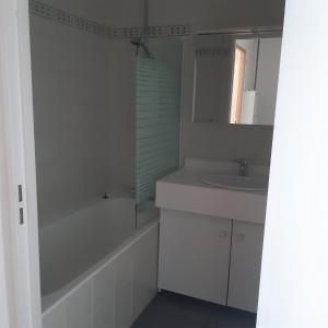 a white bathroom with a tub and a sink and a bath tubermott at Charmant studio in La Garenne-Colombes