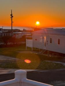 North SeatonにあるSandy bay mariners riseの夕日を背景に見える白い家
