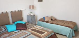 une chambre avec deux lits et une table avec une lampe dans l'établissement l'echoppe rochelaise, à La Rochelle