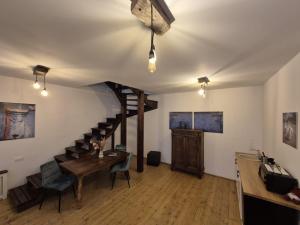 a room with a staircase and a table and chairs at Zengő in Miercurea-Ciuc