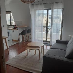 a living room with a couch and a table at Charmant studio in La Garenne-Colombes