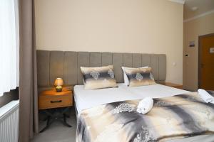 a bedroom with two beds and a night stand at Kispet Deluxe Hotels&Suites in Oberhausen