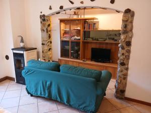 a living room with a blue couch and a tv at Nido d'Aquila in Schilpario