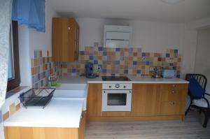 a small kitchen with a stove and a sink at Ferienwohnungen Treiber in Eggenstein-Leopoldshafen - Nähe KIT Campus Nord und Karlsruhe in Eggenstein-Leopoldshafen +3 photos