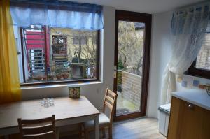 a dining room with a table and two windows at Ferienwohnungen Treiber in Eggenstein-Leopoldshafen - Nähe KIT Campus Nord und Karlsruhe in Eggenstein-Leopoldshafen