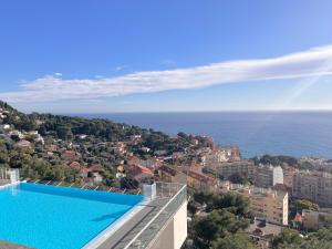 a swimming pool on top of a building with a view of the ocean at SARA RIVIERA Costa Plana in Cap d'Ail