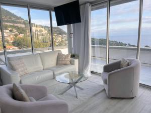 a living room with white furniture and large windows at SARA RIVIERA Costa Plana in Cap d'Ail