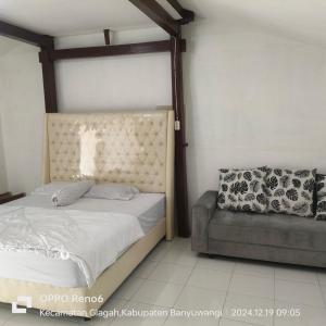 a bed and a chair in a bedroom at Tiara Homestay Banyuwangi in Banyuwangi