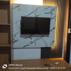 a flat screen tv sitting on a wall at Tiara Homestay Banyuwangi in Banyuwangi