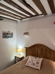 een slaapkamer met een bed en een houten plafond bij Une Pause Chez Julien, appartement lumineux et idéalement situé! in Honfleur