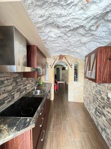 a kitchen with a sink and a stone wall at La casita medieval in Bedmar