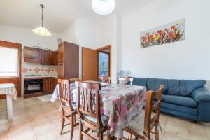 a kitchen and dining room with a table and a blue couch at Casa Vacanze delle More in Costa Rei