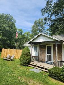 une maison dotée d'une terrasse couverte avec un drapeau. dans l'établissement Acadia Lobsterman's Farmhouse & Cottage, à Lamoine Beach
