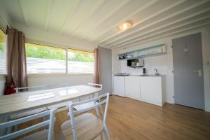 a kitchen with a table and chairs in a room at CAMPING LES GRAVELETS 2étoiles in Montmartin-sur-Mer