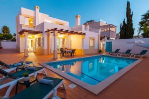 a villa with a swimming pool in front of a house at Villa Azzurra by Algarve Vacation in Albufeira