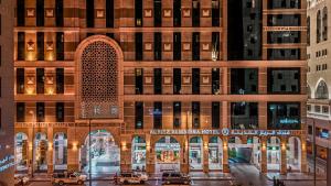 a tall building with cars parked in front of it at Al Ritz Al Madinah in Al Madinah